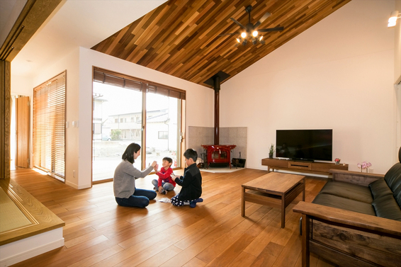 薪ストーブに人々が集まる平屋の家