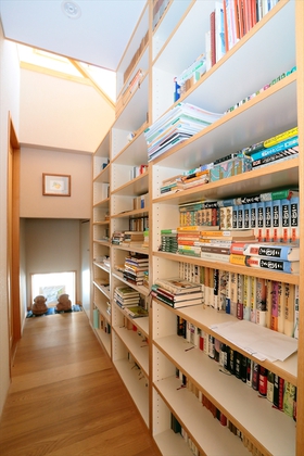 階段下には読書好きなお父様の書架を置き、わが家のライブラリー空間に。