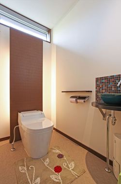 間接照明・アクセントタイルや陶器の手洗いボウルを採用した魅せるトイレ。